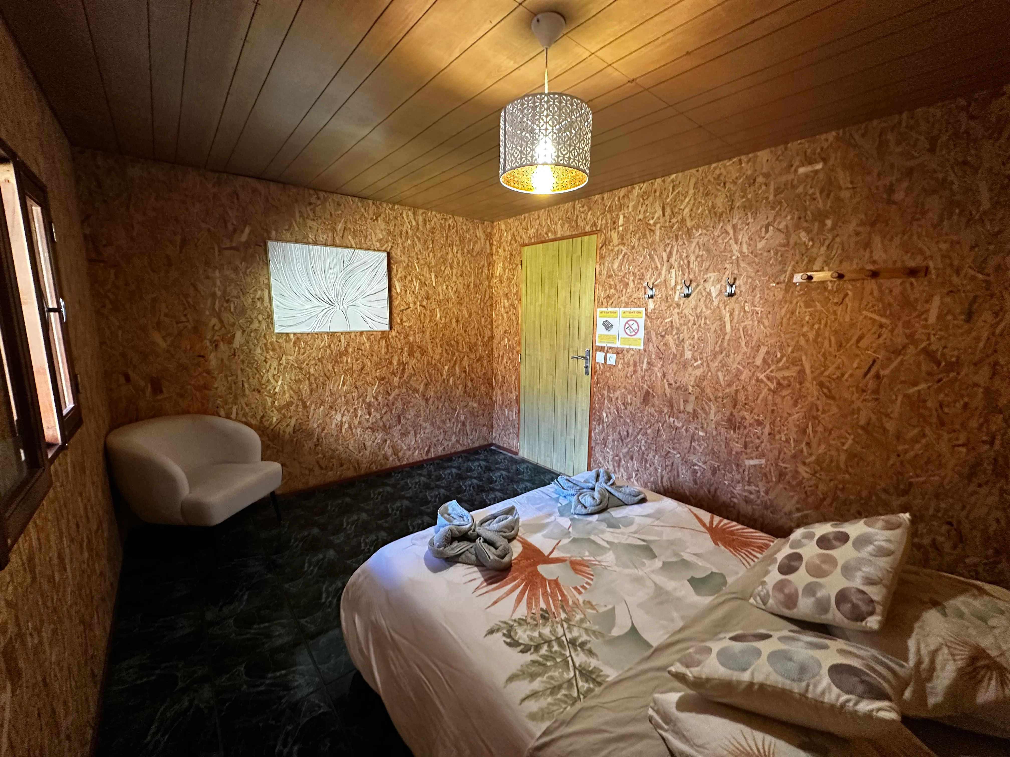 Chambre double n°2 du gîte : lit double, parois en bois, décoration sobre