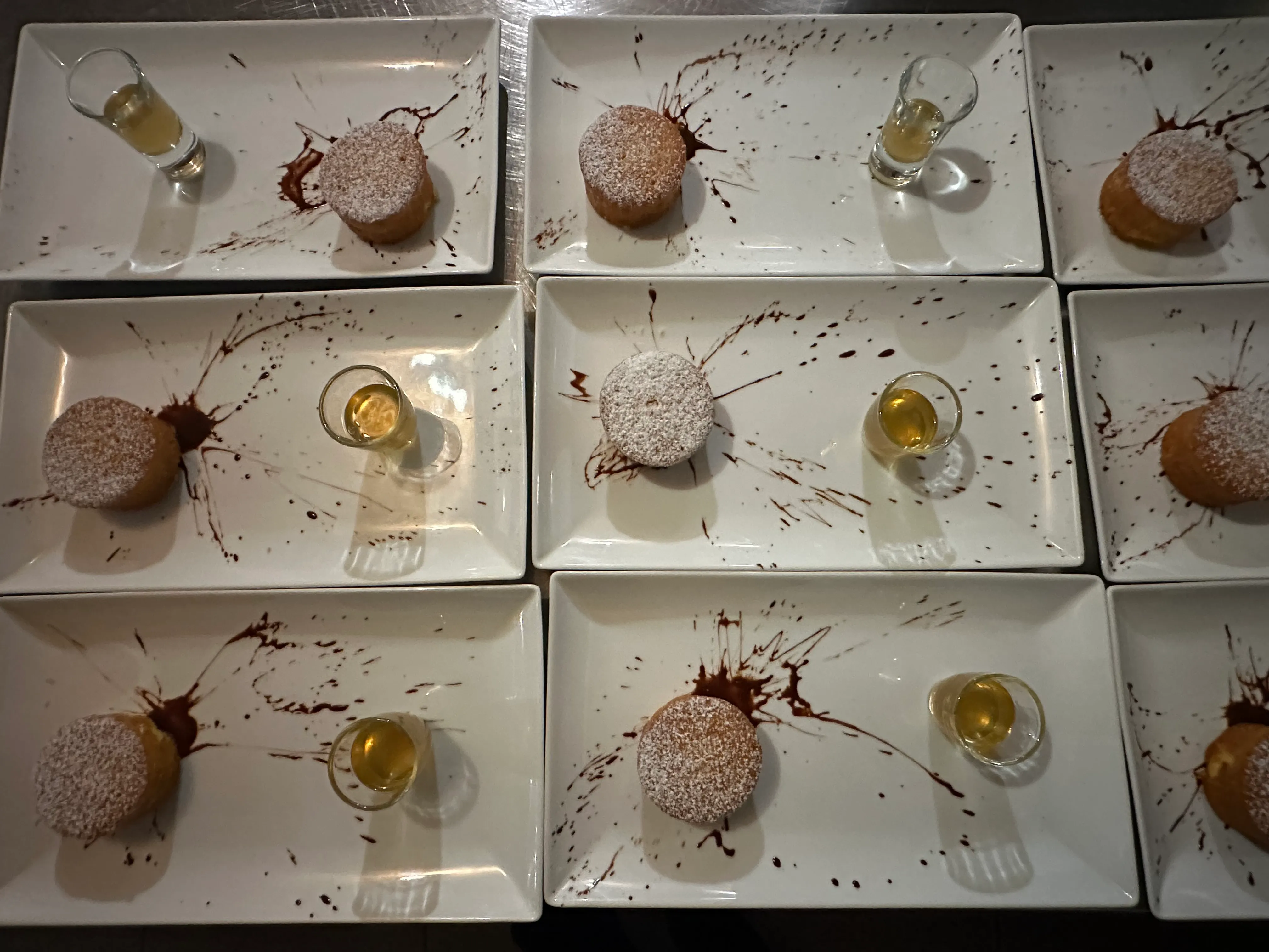 Desserts dressés à l'assiette : gâteaux au sucre glace, traits de chocolat et petit verre en accompagnement